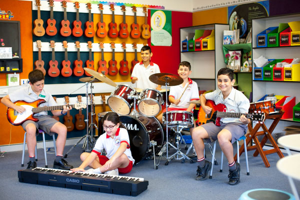 Group of students playing musical instruments in music room